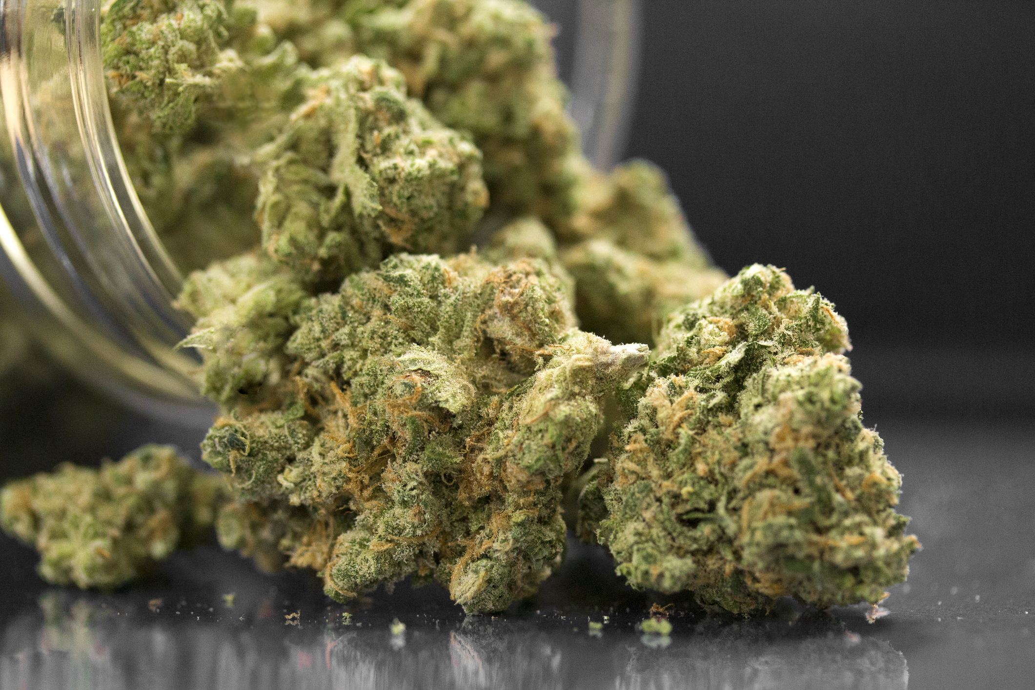 Close Up Of Cannabis Flowers In Jar And Table